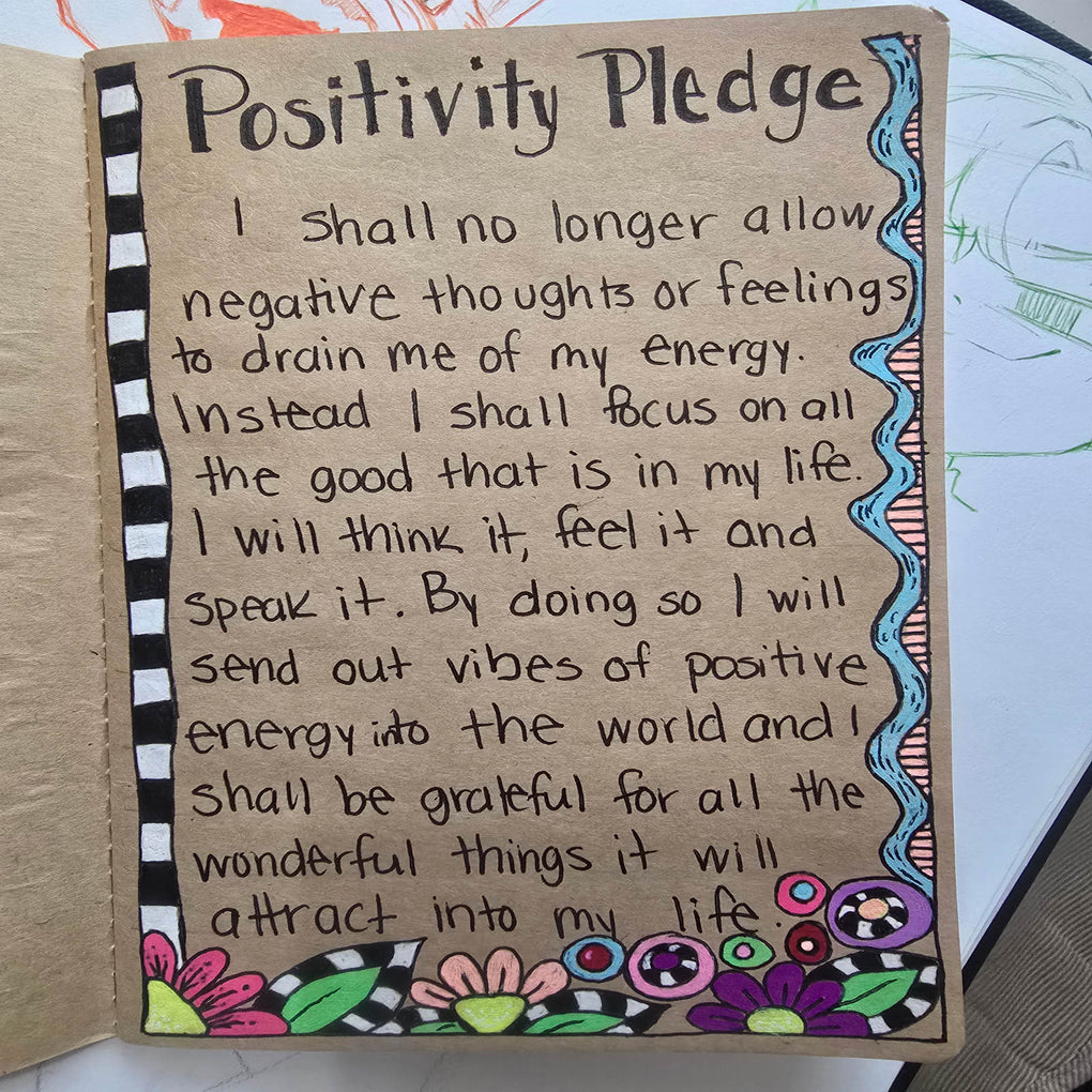 Hand drawn positivity pledge illustration by Polendo Design with colorful floral border in a sketchbook.